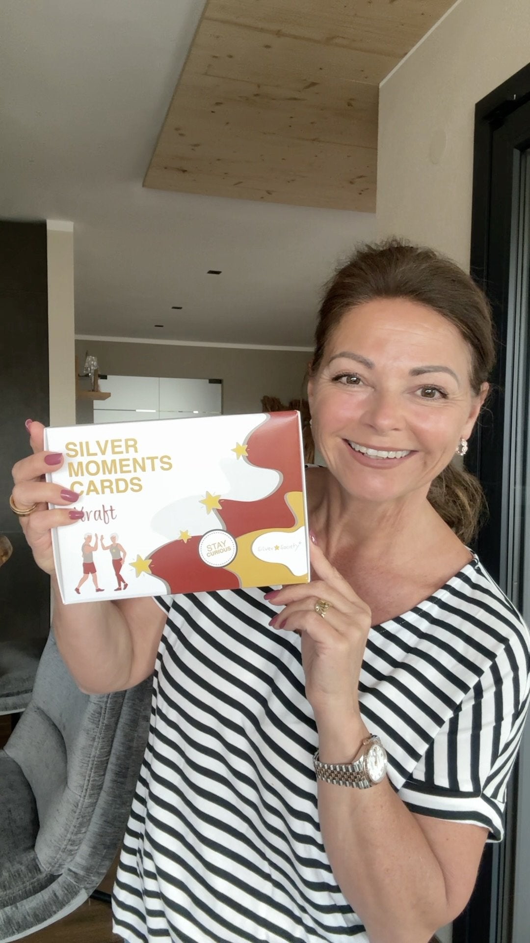 Frau hält stolz ihr Silver Moments Cards Set in die Kamera
